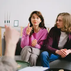 Para omawia problemy w związku, kobieta gestykuluje, mężczyzna słucha.
