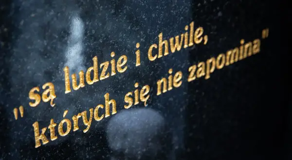 Są ludzie i chwile, których się nie zapomina" - złoty cytat na pożegnanie, wyryty na czarnym kamieniu.
