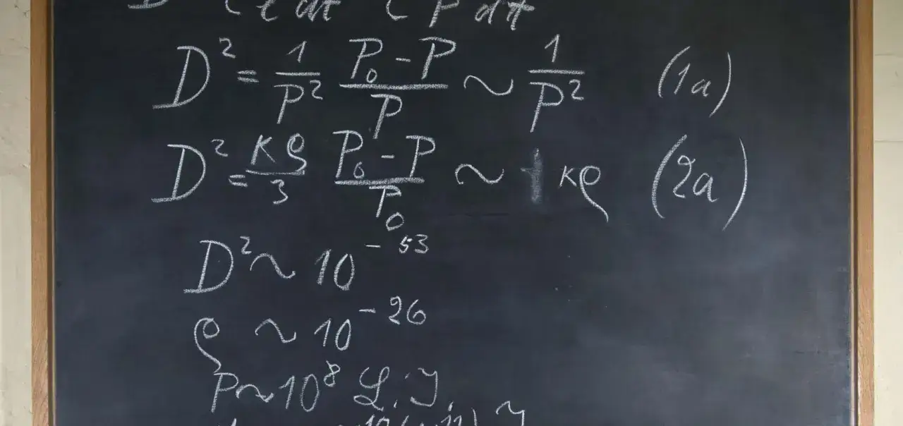 Na tablicy wzory fizyczne, jakby złote myśli Alberta Einsteina. Wzory z wykładnikami i symbolami, jak w jego cytatach o nauce.