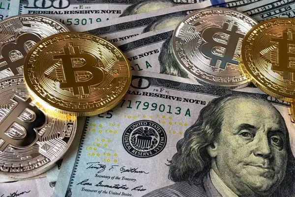 Złote i srebrne monety Bitcoin leżą na banknotach dolarowych. To obraz, który inspiruje do refleksji nad przyszłością pieniędzy i cytatami o finansach.